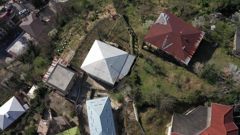Flying over the rooftops of the Kutaisi, Georgia, mountain river bridge, aerial view.