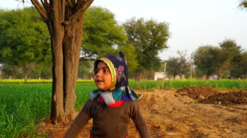 20 January 2021- Chomu, Jaipur, India. 4K footage of Open minded smiling kid, jumping in the air and enjoying childhood outdoors. Ecstasy moment of childhood concept.