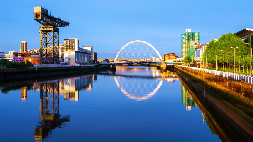 Glasgow, Scotland. View of Glasgow, UK landmarks - Finnieston Crane and Squinty bridge at sunset. Time-lapse with colorful twilight sky, zoom in