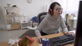 Excited young asian japanese lazy girl gamer in headsets and glasses playing video game during summer break at cozy home.
