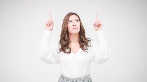 Young woman pointing a point in front of a white wall