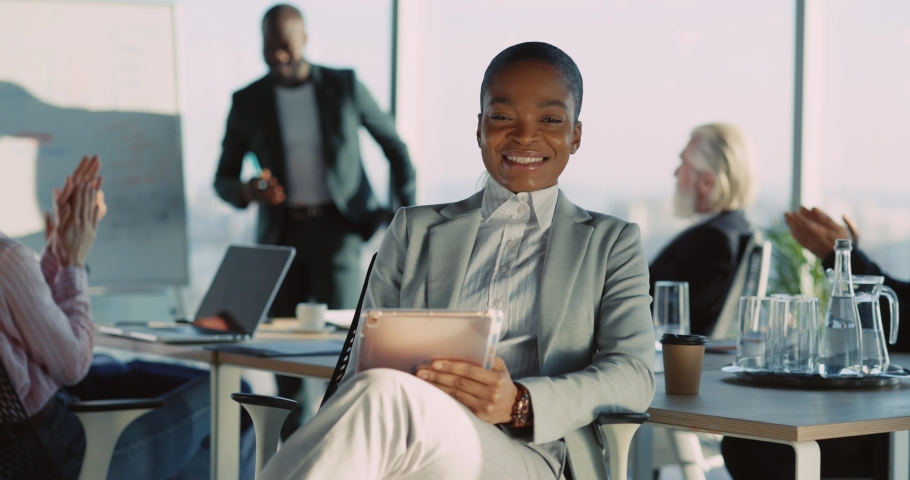 NEW YORK - 19 May 2018: Portrait of sexy beautiful african businesswoman smiling to camera sitting at table on public corporate meeting indoors. Business people. | Shutterstock HD Video #1066314796
