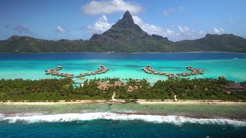 Drone aerial view Bora Bora Tahiti, 4k. Tropical paradise island, turquoise crystal clear water lagoon, overwater bungalows. French Polynesia.