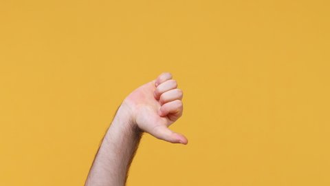 Cropped close up man male hand showing different signs thumbs up down like dislike gesture isolated on yellow background studio. Copy space commercial promo advertisement Advertising workspace mock up