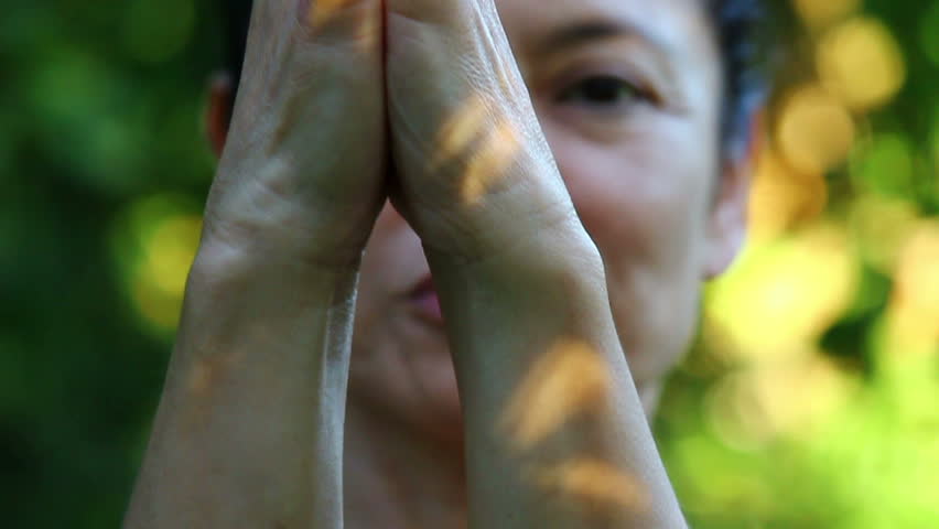Woman is exercising yoga in the garden - Close-up of hand. Face in background