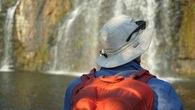 Unrecognizable hiker enjoying view of majestic waterfall. Adventure concept - Powered by Shutterstock - Get 15% off with code: PIKWIZARD15