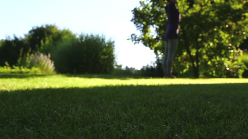 Woman is exercising yoga in the garden - Foreground sharp - background blurred -