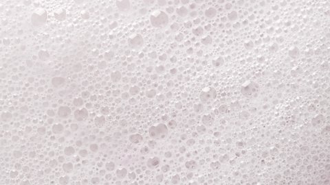 Texture of white soap foam with bubbles abstract background.