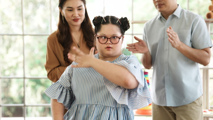 Down syndrome children dance and enjoy life. Children with disabilities doing activity to show their parents. Down Syndrome girl danced proudly and recorded the clip video to share in Social media. Royalty-Free Stock Footage #1066355317