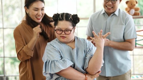 Down syndrome children dance and enjoy life. Children with disabilities doing activity to show their parents. Down Syndrome girl danced proudly and recorded the clip video to share in Social media.