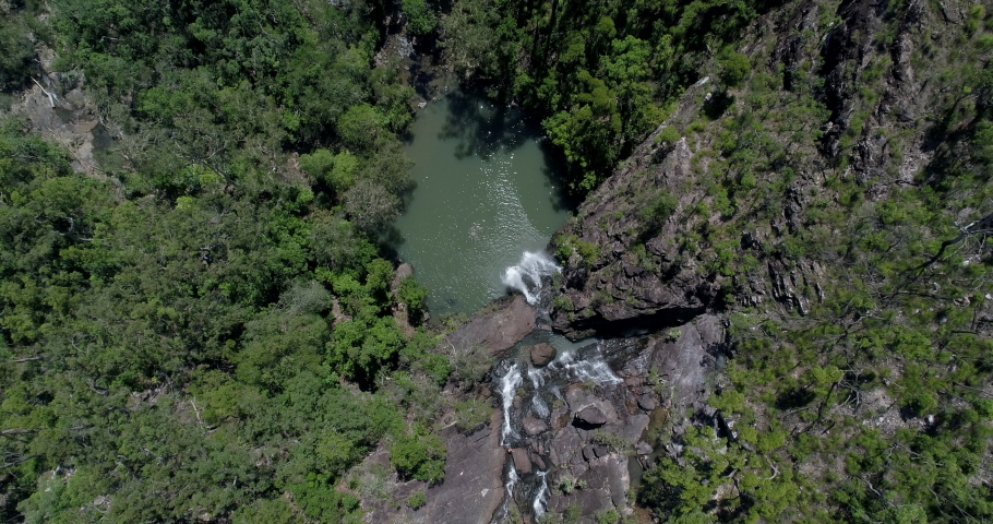 4K aerial view descending directly above of Cedar Creek Waterfall in good water flow, Cedar Creek Falls is situated  between Proserpine and the town of Airlie Beach, proserpine, Queensland, Australia