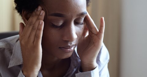 Close up portrait of frustrated depressed young african american woman feel stress anxiety, worried tired upset mixed-race lady suffer from feeling unwell headache, girl learns bad news going through