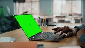 Close Up on Hands of Black African American Specialist Working on Laptop Computer with Green Screen Mock Up Display at Home Living Room. Freelance Man Chatting to Clients Over the Internet. - Powered by Shutterstock - Get 15% off with code: PIKWIZARD15