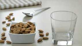 Serving  almond milk in a glass cup with dried almond nuts