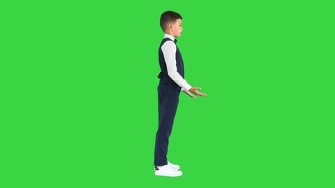 Little boy in a bow tie and waistcoat talking on a Green Screen, Chroma Key.