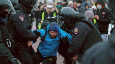 Russia, Moscow, January 23, 2021: Police force detain protester rebel man. Policeman arrest people. Political strike out riot. Convict offender. Crowd activist demonstration. Human right. City street.