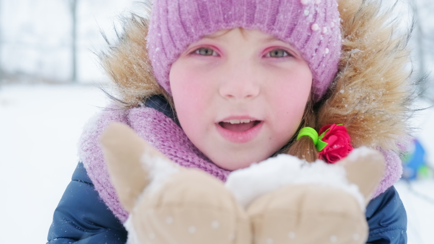 Kid blows snow. Pre teen girl blows snow into the camera and suddenly disappears Royalty-Free Stock Footage #1066378387