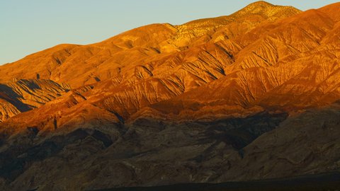 Time lapse of sunset rays illuminating distant mountain in Death Valley, California