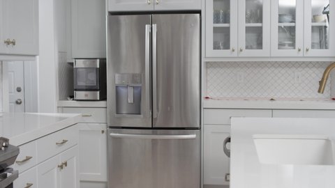 Refrigerator in clean white modern kitchen. Home appliance beauty shot dolly