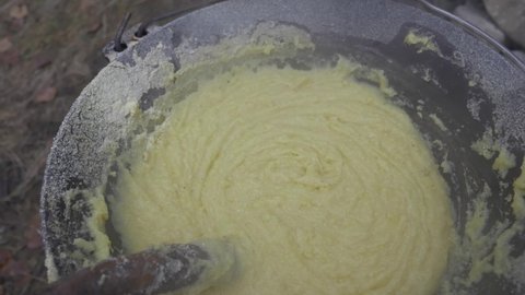Hot Polenta, Or Cornmeal, Cooked In A Cauldron With Wooden Stick Used In Stirring, close up, high angle