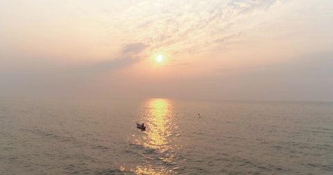 A fisherman in a boat with the sun setting in the back capture with a drone in the Arabian sea from the coast of Mumbai, where the next coastal road project will be coming up.