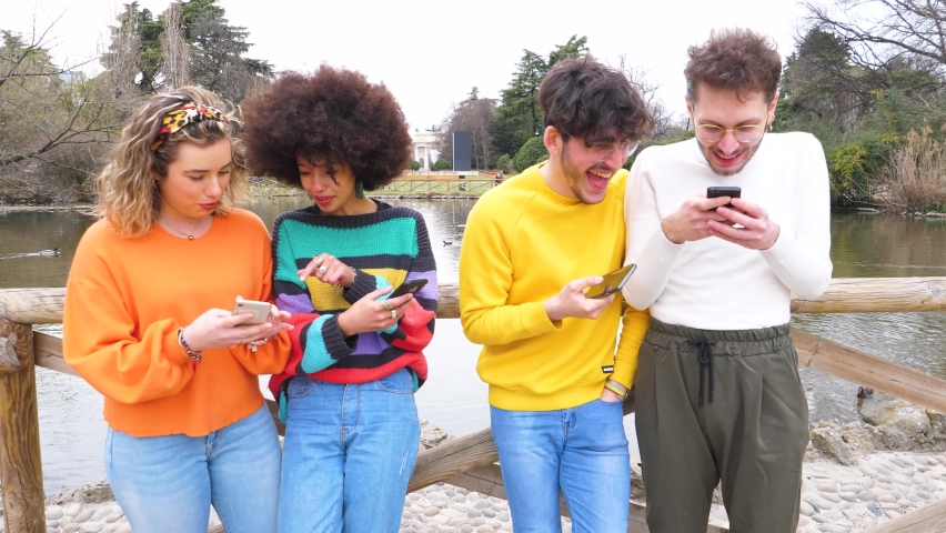 Group of multiethnic friends millennials using mobile phones smiling happy enjoying time together and social viral trends Royalty-Free Stock Footage #1066407892