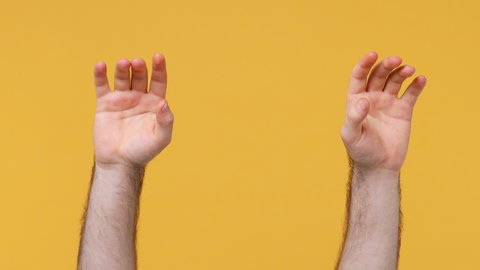 Cropped close up man male hands depicting heavy metal rock sign horns up gesture fooling fan rock-n-roll isolated on yellow background studio. Copy space commercial promo Advertising workspace mock up