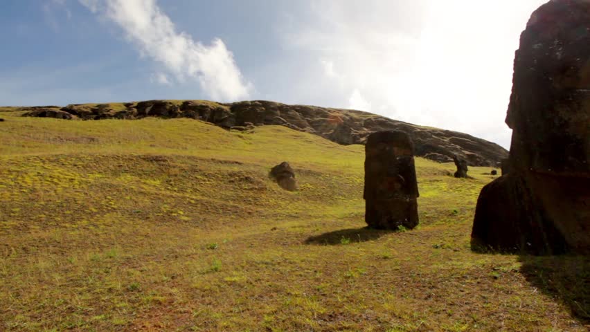 Easter Island statues stand in a line at dawn.