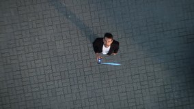 Big City Businessman Uses Smartphone, Stands on Crowded Street. E-Commerce Visualization of Information Lines Flying from Mobile Phone into Global Digital Network. Top-Down Zoom out Aerial Drone Shot - Powered by Shutterstock - Get 15% off with code: PIKWIZARD15