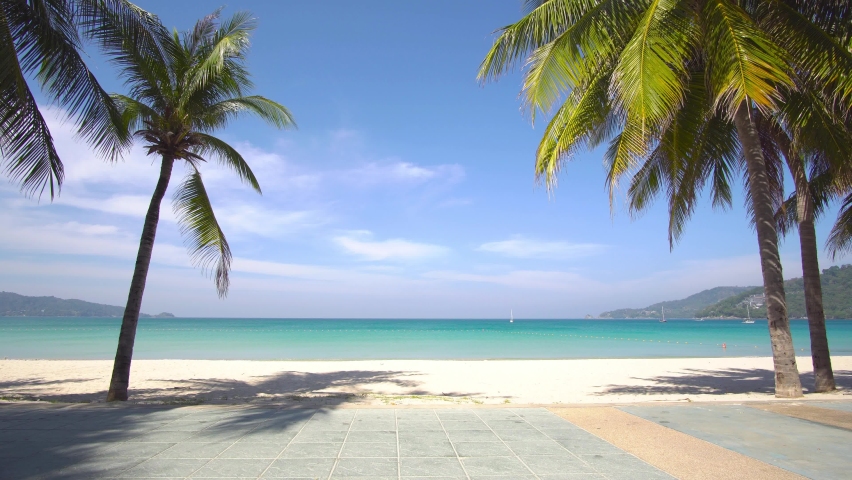Phuket Thailand Beach Sea. Scene of Landscape view of Palm at beach Beach sand on blue sea water clear and sky clear background. Camera on dolly slide. At Patong Beach, Phuket, Thailand. Royalty-Free Stock Footage #1066420447
