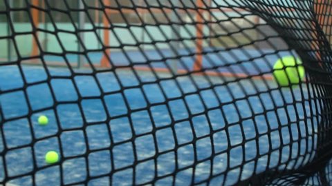 Slow motion through grid view of paddle tennis man playing on blue court outdoors. One caucasian paddle player sportsman hitting the ball. Racquet sport game Concept.-Dan