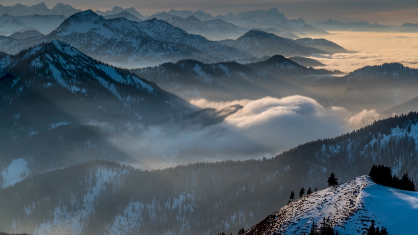 Alps mountins at winter with snow fog clouds zugspitze bavaria germany karwendel mystic clouds sun lights.
