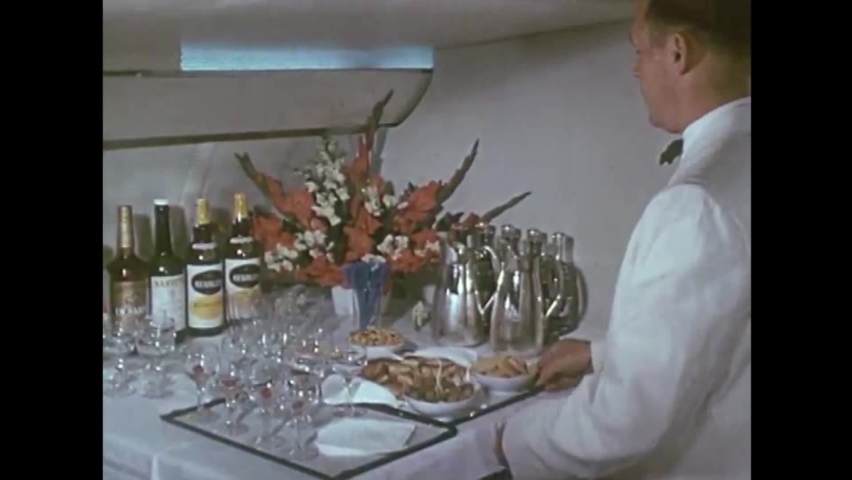 CIRCA 1950s - Elaborate food and drinks are served on an airplane in 1959. | Shutterstock HD Video #1066436488