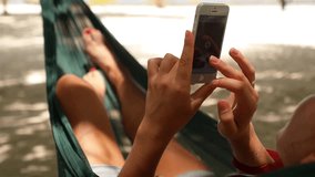 Woman using smartphone in a Hammock and flying animation 3D heart icons from device. Collected Likes Concept. - Powered by Shutterstock - Get 15% off with code: PIKWIZARD15