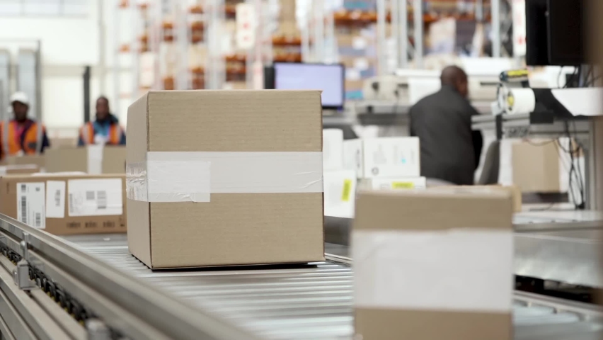 Packages and cardboard boxes traveling on an automated conveyor belt at large goods distribution warehouse. | Shutterstock HD Video #1066450780