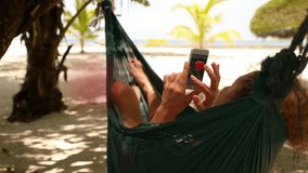 Woman holding smartphone Relaxing in a Hammock and getting animation heart symbols. Collected Likes Concept. - Powered by Shutterstock - Get 15% off with code: PIKWIZARD15