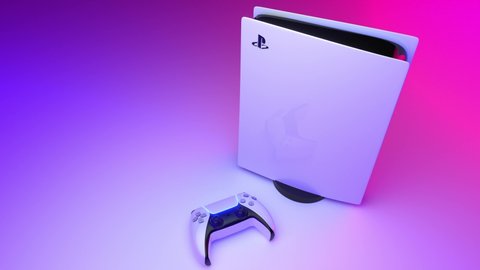 Moscow, Russia - January 20 2021:  Sony PlayStation 5 home video game console and game controller. New product from Sony, wireless white PlayStation 5 on multicolored neon background