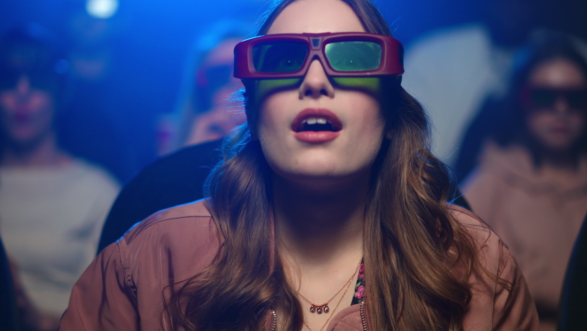 Closeup young woman watching interesting film in movie theater. Portrait of amazed girl looking at movie screen. Pretty lady spending evening in 3d cinema. | Shutterstock HD Video #1066456480