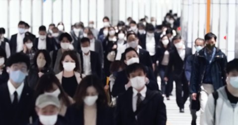 Covid-19 : Crowd of people wearing masks walking to work