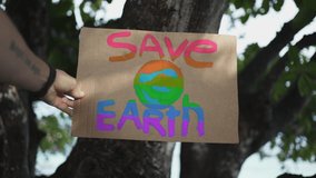 A rainbow colored poster from the demonstration "Save the Earth" from plastic pollution of the seas and oceans and global peace. - Powered by Shutterstock - Get 15% off with code: PIKWIZARD15