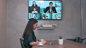Asian woman working on laptop and online video conference with colleagues self-isolation at home while coronavirus pandemic social-distancing
