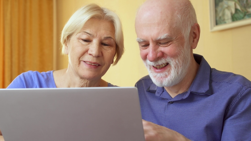 Senior couple at home using laptop. Retired family working on computer learning social media. Computer literacy among elderly people active modern lifestyle on retirement | Shutterstock HD Video #1066468345