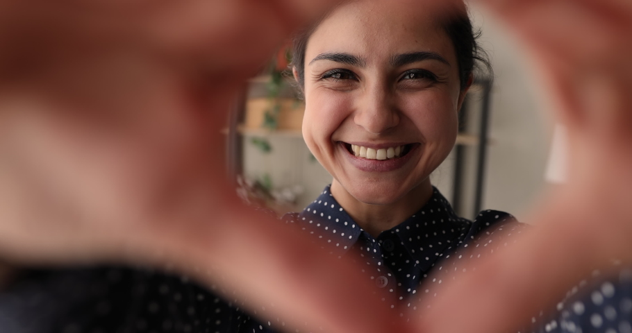 Close up sincere smiling young mixed race indian woman showing love symbol to camera, expressing romantic feelings. Healthcare insurance, cardiology examination, social work, donation charity concept. | Shutterstock HD Video #1066471381