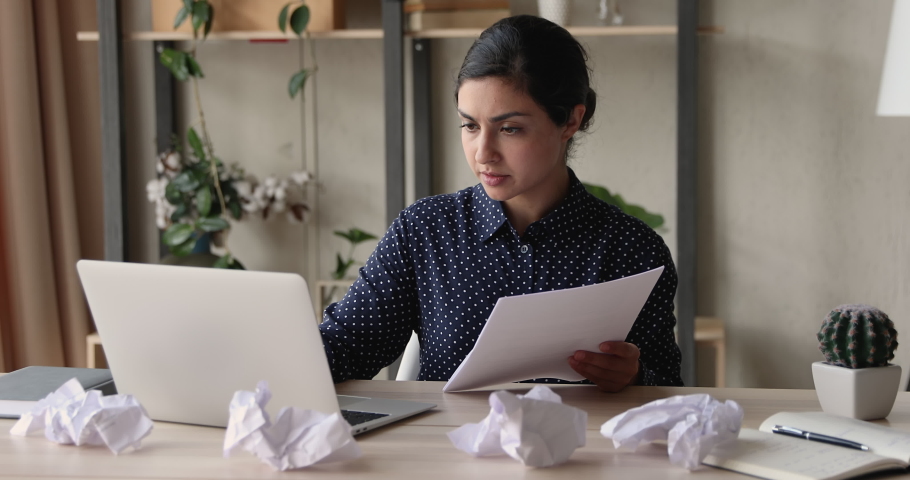 Stressed young mixed race indian business lady feeling nervous, doing paperwork. Anxious depressed female multiracial employee crumpling paper documents, standing leaving workplace, deadline concept. Royalty-Free Stock Footage #1066471507