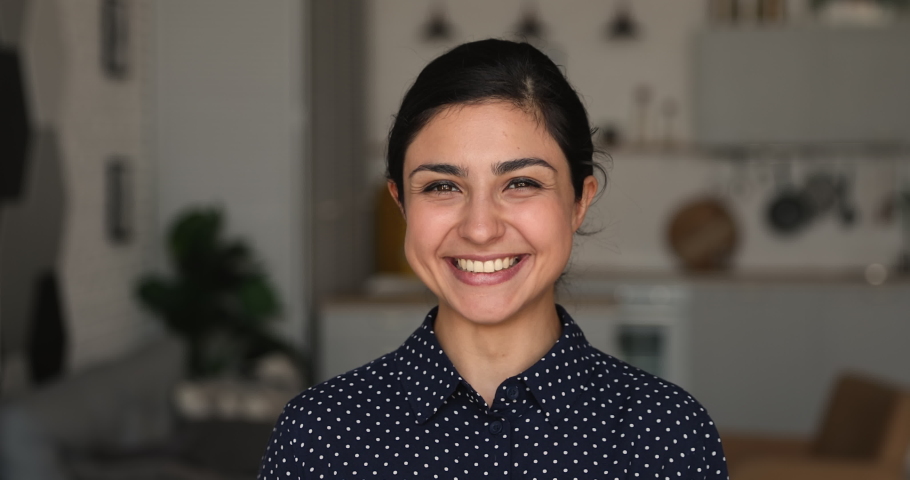 Head shot happy millennial mixed race woman looking at camera, showing perfect white toothy smile, feeling confident at home office. Attractive female indian client satisfied with stomatology service. Royalty-Free Stock Footage #1066471627