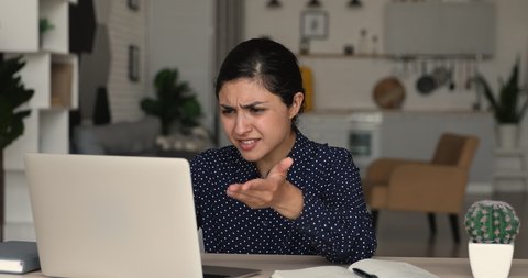 Confused nervous millennial mixed race indian woman looking at computer screen, feeling stressed of reading notification with bad news, getting bank loan rejection or dismissal notice by email.