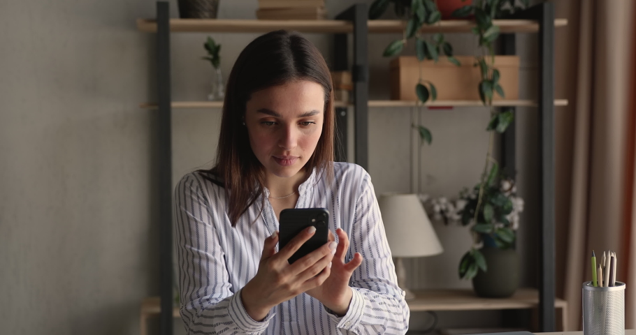 Stressed nervous young woman looking at cellphone screen, feeling frustrated of receiving message or email with bad news. Unhappy millennial female user dissatisfied with bad electronic device work. Royalty-Free Stock Footage #1066472434