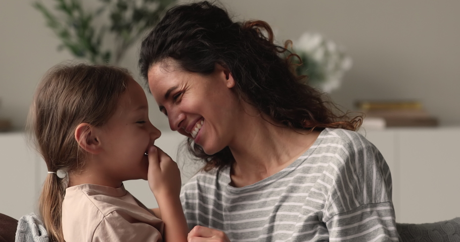 Close up portrait loving mother cuddles little daughter, family sit on sofa touch noses feel unconditional love show devotion, express caress. Caring mom, adopted kid, Mothers Day celebration concept Royalty-Free Stock Footage #1066486714