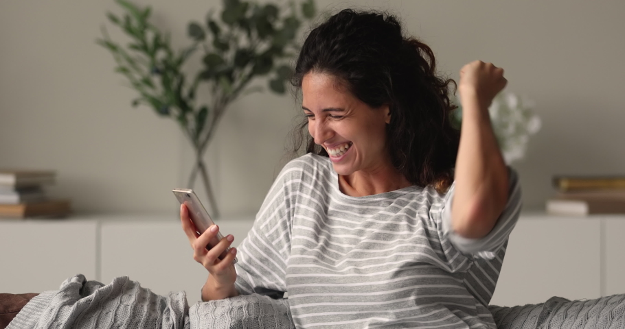 Happy woman holding smartphone screams with joy celebrate online lottery win, received message of loan approval. Shopper got notice about fantastic commercial offer, great discount and sales concept | Shutterstock HD Video #1066486909