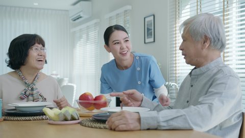 Attractive young senior asian citizen couple happy sit, talk, eat soup for healthy nutrition breakfast meal on dining table at home in morning in routine lifestyle in old asia nursing in-home care.